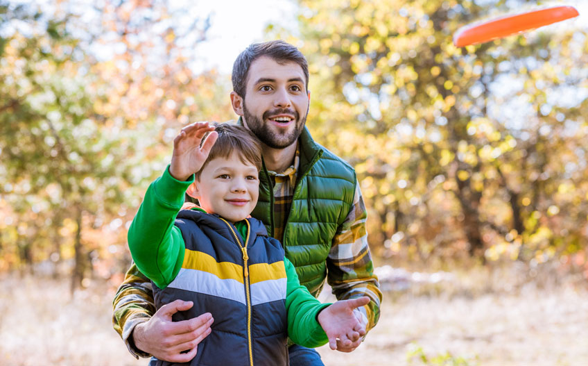 Father and son throwing a glow disc golf disc